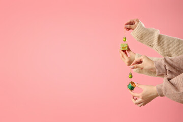 Female hands with beautiful Christmas decorations against pink background