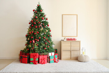 Interior of living room with Christmas tree, blank frame and drawers