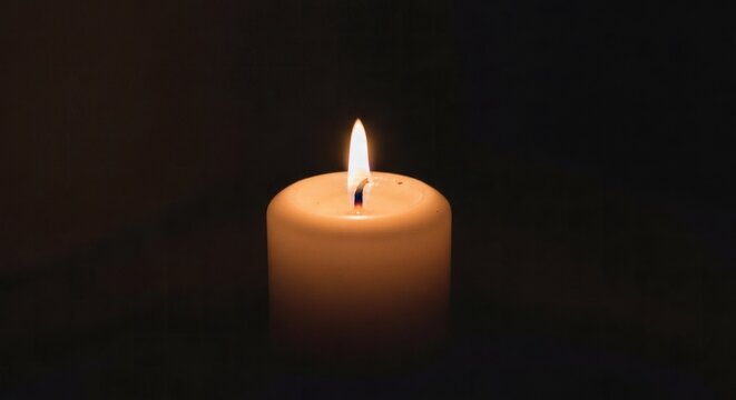 A single burning candle flame glowing warmly in the deep darkness, symbolizing hope, peace, and remembrance