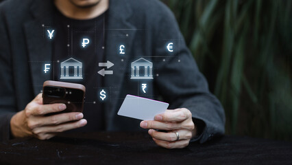 Man using smartphone and credit card for online banking with global currency exchange concept