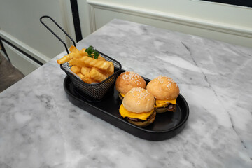 Delicious mini burgers with fries on a table, ready to be enjoyed!