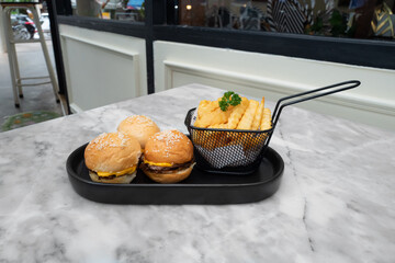 Delicious burgers and fries artfully arranged on a marble table, a culinary delight. A simple yet eye-catching composition