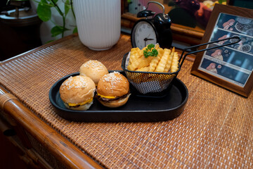 A delightful presentation of mini burgers and fries on a serving tray