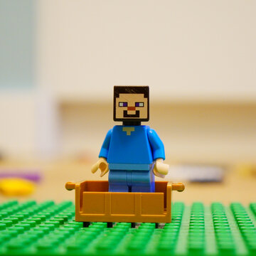 Minecraft Steve Lego figure in a toy cart on a green Lego base