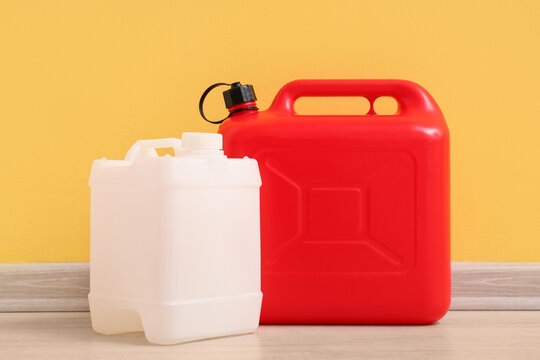 Different plastic canisters near yellow wall