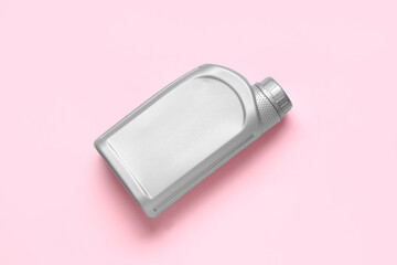 Grey plastic canister on pink background