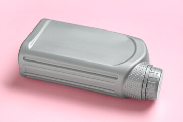 Grey plastic canister on pink background