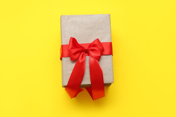 Books tied with red ribbon on yellow background