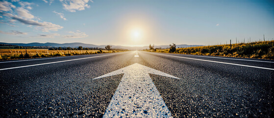 An asphalt road stretches into the distance with a painted white arrow pointing forward, symbolizing motivation, progress, and the concept of continuous growth and forward movement	