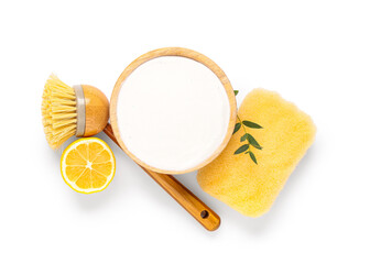 Bowl of baking soda with lemon, cleaning sponge and brush on white background