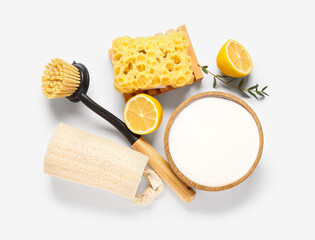 Bowl of baking soda with lemon and cleaning supplies on white background