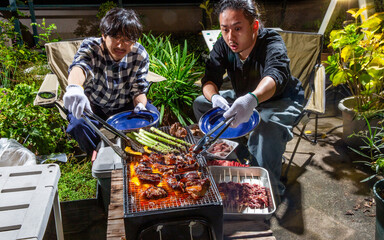 スペアリブのバーベキューをベランダで楽しむ男性