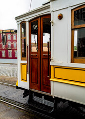 A close-up of a vintage tram car with wooden doors and yellow accents.