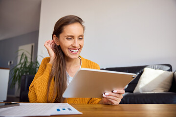 Cheerful woman at her apartment using digital tablet