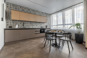 Modern Bright Kitchen with Patterned Tile Wall and Black Dining Set