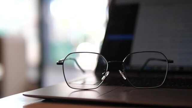 Eyeglasses on laptop with blurred background &ndash; concept of work, study, focus, and lifestyle in cozy natural light