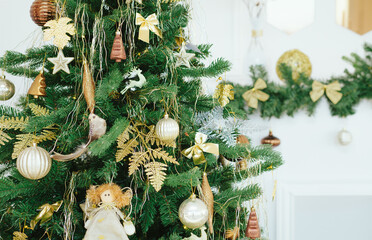 Decorated Christmas tree close up. Holiday background. Christmas tree in white interior. Christmas decorations.  Light Christmas wallpaper.