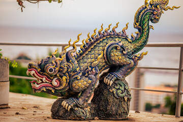 Background of Thailand's Chonburi religious attractions (Wat Khao Phra Khru viewpoint), with beautiful Buddha and Phaya Naga statues, tourists always come to make merit and take pictures at night.