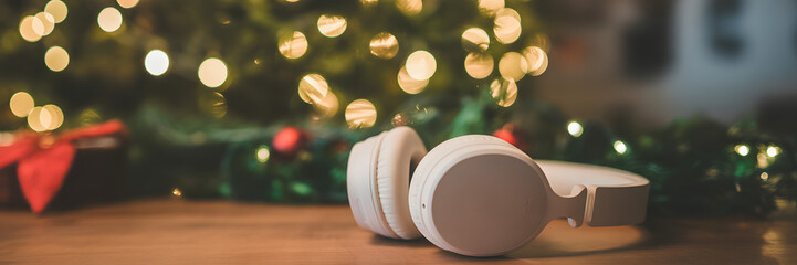 Christmas Melodies: A pair of pristine headphones rests near a twinkling christmas tree, a symbol of joyful yuletide tunes and serene moments.