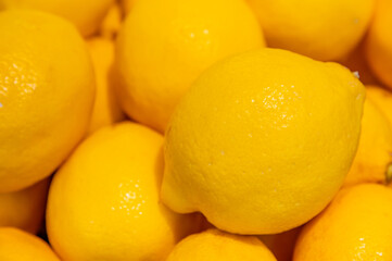 Photo background of fresh, ripe and yellow lemons at the supermarket.