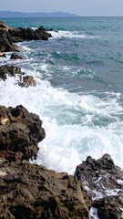 Rocky shore with white sea foam showing natural coastline environment and marine ecosystem