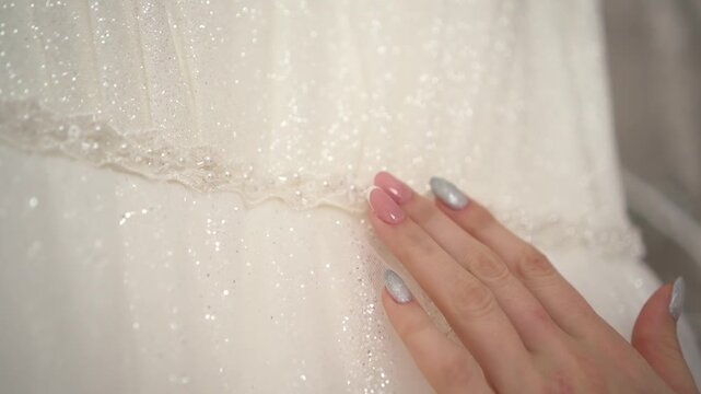 the bride strokes the wedding dress with her hand 02