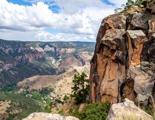 Steep rocky cliff overlooking deep valley showing rugged natural terrain