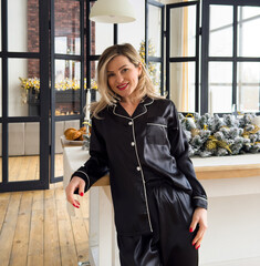 Dreamy young adult woman smiling, spending new year holidays at home, waking up in bedroom with decorated christmas tree