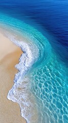 Obraz premium Shallow Turquoise Water Gently Laps A Sunlit Sandy Beach With Sparkling Light Reflections Under A Clear Blue Sky