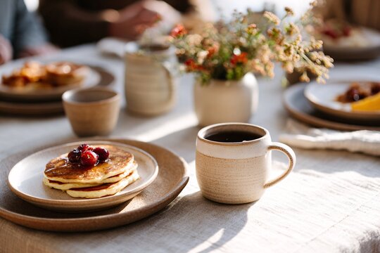Family enjoying breakfast with pancakes and coffee around the table