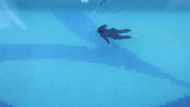 Aerial Top View Woman Swimmer Swimming in Swimming Pool. Professional Athlete Training for the Championship, using Front Crawl, Freestyle Technique. Top View Shot
 - Powered by Adobe