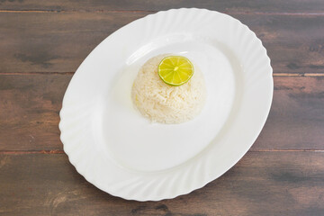 Riz blanc, side dish traditionnel de la cuisine du monde sur une assiette blanche et table en bois. Accompagnement. 