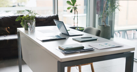 Fototapeta premium Empty office, laptop and tablet with documents for data analysis, stats review and financial growth. Desk, computer and digital tech with paperwork for research info, business report and investment.