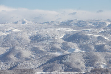 Mountains and valleys in snowy Hokkaido winter landscape, Rusutsu, Japan