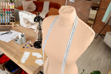 Tailor's mannequin with measuring tape in atelier, closeup