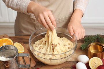 Young woman making dough for Panettone near table in kitchen. Christmas food concept
