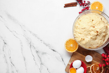 Bowl of dough for Panettone with ingredients and Christmas decor on white grunge background
