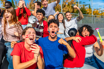 Excited young sports fans celebrating a goal in stadium