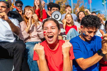 Young excited multi ethnic fans cheering at stadium
