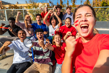 Fototapeta premium Excited young sports fans taking selfie at stadium