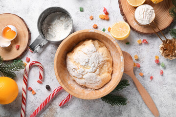 Bowl of dough for Panettone with ingredients and Christmas decor on white grunge background