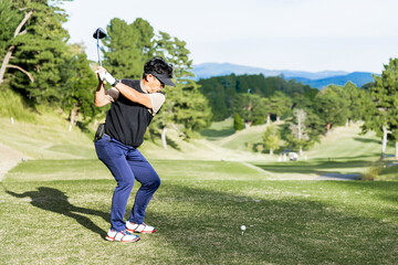 ゴルフを楽しむ日本人のミドル男性