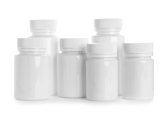 Many blank plastic vitamin bottles on white background