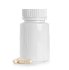 Blank plastic vitamin bottle and pills on white background