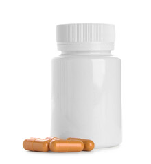 Blank plastic vitamin bottle and pills on white background
