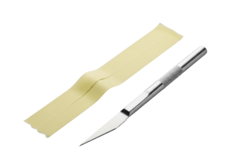 A light yellow masking tape strip with torn edges, angled 45 degrees, beside a sleek silver craft knife, on a seamless transparent background, close-up studio concept of minimalist precision