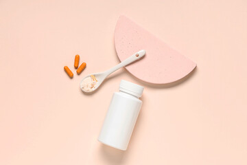 Blank plastic vitamin bottle with pills and spoon of powder on beige background