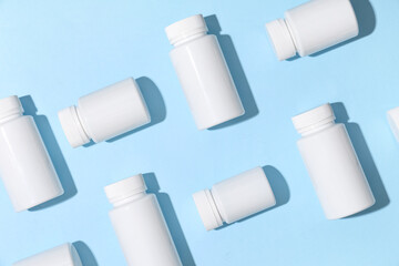 Many blank plastic vitamin bottles on blue background