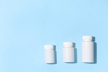 Blank plastic vitamin bottles on blue background
