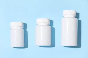Blank plastic vitamin bottles on blue background